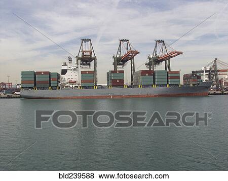 Stock Photo - Cranes above cargo containers on freighter. Fotosearch