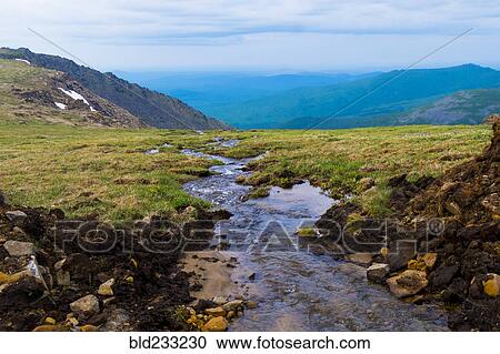 Stock Image - Creek flowing in mountains. Fotosearch