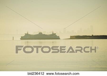Stock Image - Cruise ship near city skyline at sunset. Fotosearch