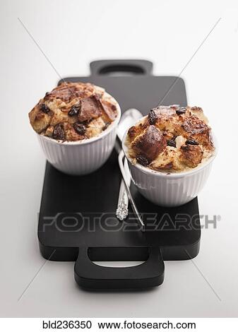 Stock Image - Cups of apple raisin bread pudding. Fotosearch