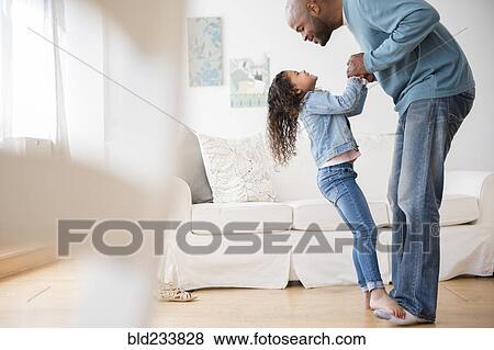 Daughter standing on feet of father and dancing View Large Photo Image Stock Photo - Daughter standing on feet of father and dancing. Fotosearch