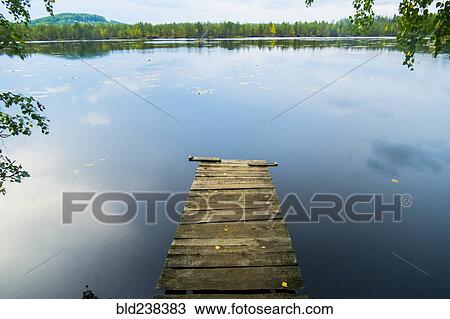 Stock Image - Dock over still lake. Fotosearch
