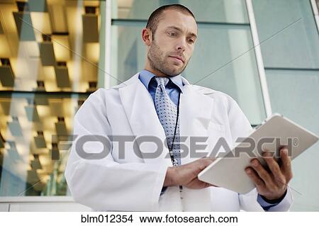 Doctor using digital tablet outdoors View Large Photo Image Picture - Doctor using digital tablet outdoors. Fotosearch