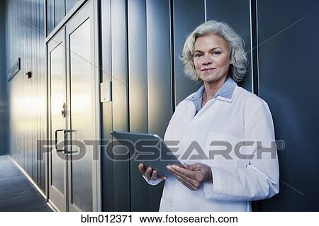 Stock Image - Doctor using digital tablet outdoors. Fotosearch