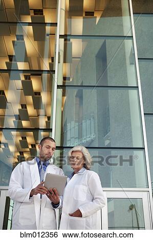 Stock Photograph - Doctor's using digital tablet outdoors. Fotosearch