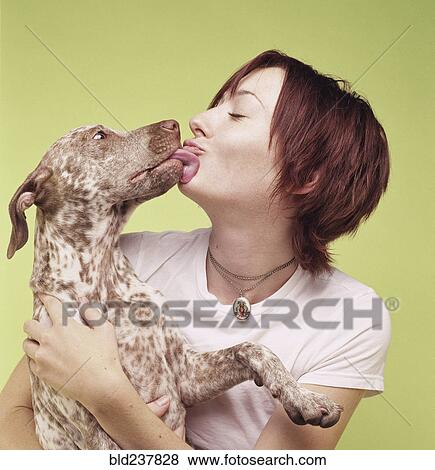 Stock Photo - Dog licking face of woman. Fotosearch