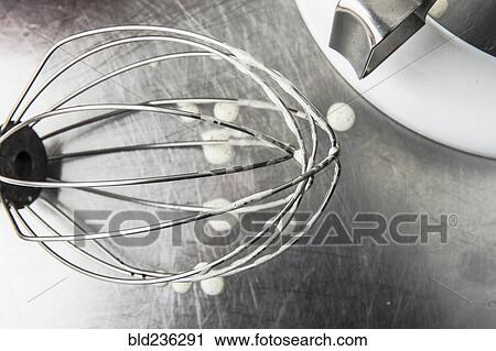 Stock Image - Droplets under wire whisk. Fotosearch