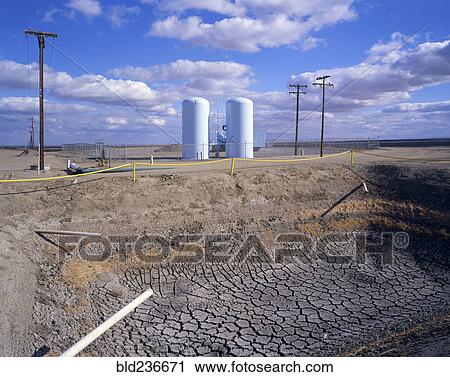 Stock Image - Dry drainage ditch near silos. Fotosearch