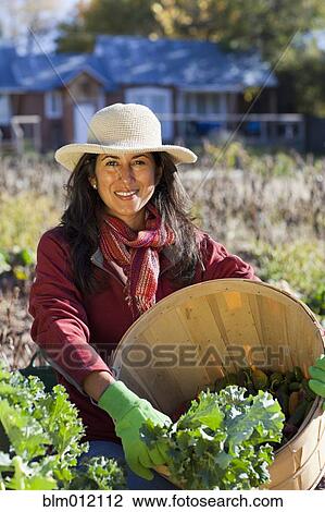Stock Image - Ecuadorian woman gardening. Fotosearch