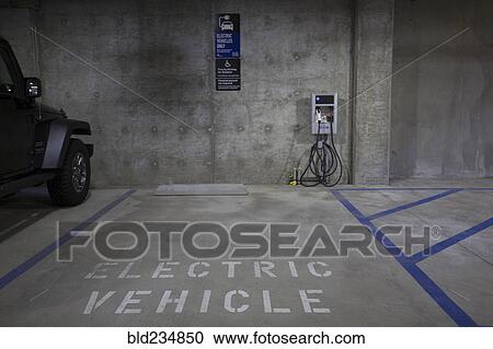 Stock Image - Electric vehicle parking space and charging station. Fotosearch
