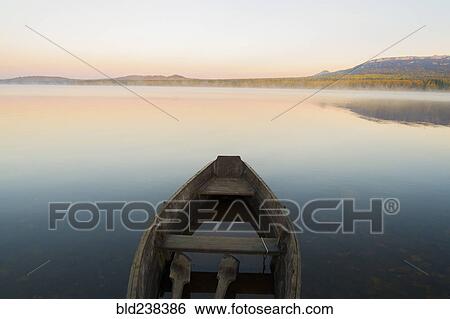 Empty rowboat on lake at sunset View Large Photo Image Stock Photograph - Empty rowboat on lake at sunset. Fotosearch