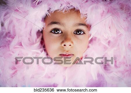 Stock Photograph - Face of Mixed Race girl surrounded by pink feather boa. Fotosearch