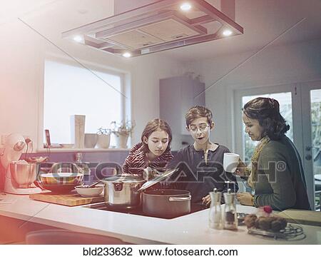 Stock Image - Family cooking food in kitchen. Fotosearch
