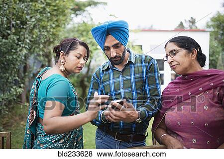 Stock Photo - Family texting on cell phone outdoors. Fotosearch