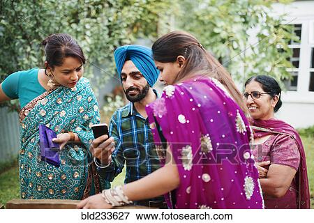 Stock Photo - Family using cell phone in backyard. Fotosearch