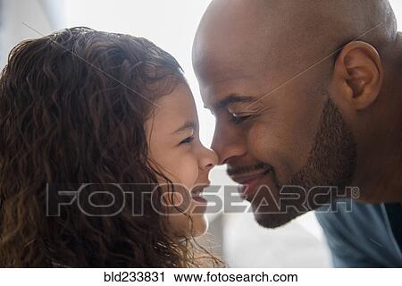 Stock Image - Father and daughter rubbing noses. Fotosearch