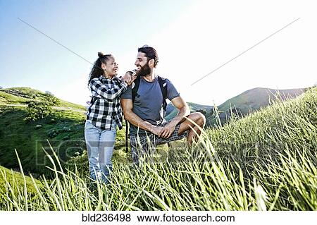 Stock Photo - Father and daughter smiling on hill. Fotosearch