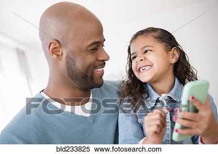 Father and daughter texting on cell phone View Large Photo Image Stock Photography - Father and daughter texting on cell phone. Fotosearch
