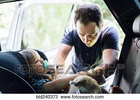 Father buckling son into car seat View Large Photo Image Stock Image - Father buckling son into car seat. Fotosearch