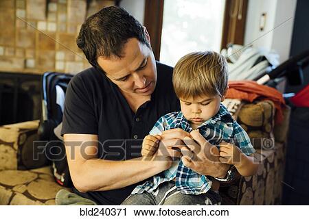 Father buttoning shirt for son View Large Photo Image Stock Image - Father buttoning shirt for son. Fotosearch