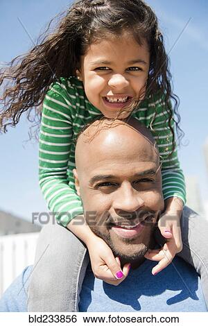 Stock Photograph - Father carrying daughter on shoulders. Fotosearch