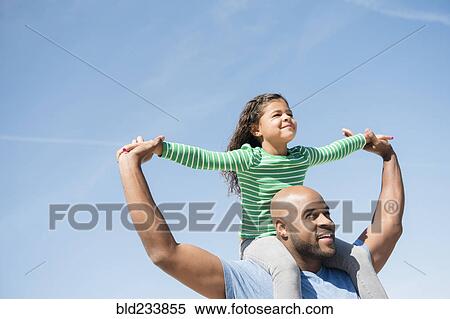 Stock Photography - Father carrying daughter on shoulders. Fotosearch