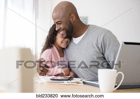 Father hugging daughter at table View Large Photo Image Stock Image - Father hugging daughter at table. Fotosearch