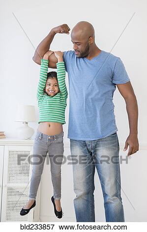 Father lifting daughter using biceps View Large Photo Image Stock Photo - Father lifting daughter using biceps. Fotosearch