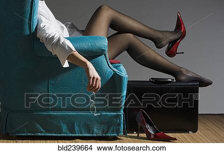 Picture - Fatigued Caucasian businesswoman unwinding in blue armchair. Fotosearch