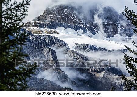 Stock Image - Fog on snowy mountain range. Fotosearch