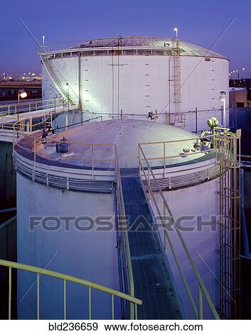 Stock Photo - Footbridge on storage tanks at night. Fotosearch