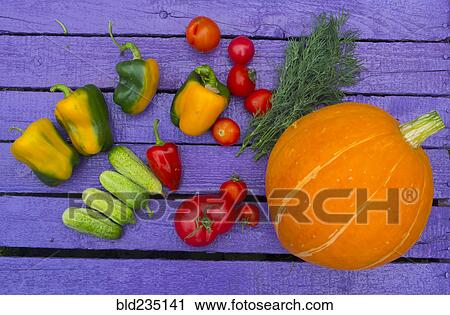 Stock Image - Fresh vegetables on purple wooden table. Fotosearch