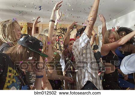 Stock Image - Friends dancing at party. Fotosearch