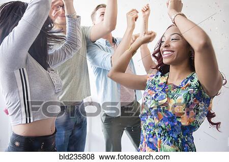Friends dancing in confetti at party View Large Photo Image Stock Photo - Friends dancing in confetti at party. Fotosearch