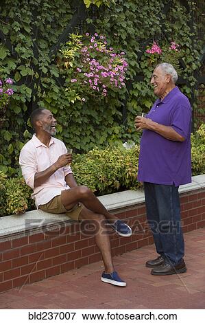 Friends drinking beer in flower garden View Large Photo Image Stock Photo - Friends drinking beer in flower garden. Fotosearch