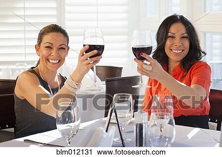 Friends drinking red wine in restaurant View Large Photo Image Stock Image - Friends drinking red wine in restaurant. Fotosearch