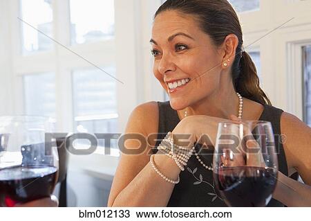 Stock Image - Friends drinking red wine in restaurant. Fotosearch