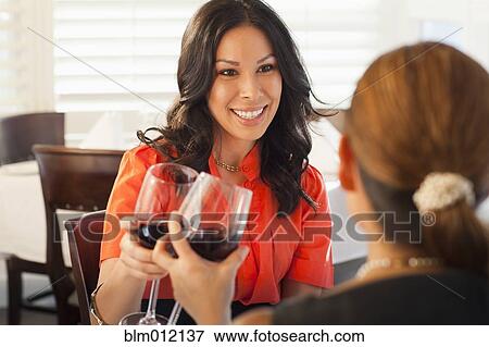 Stock Photo - Friends drinking red wine in restaurant. Fotosearch