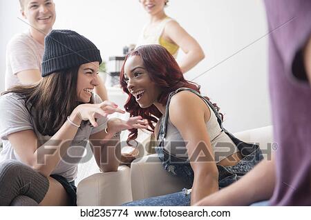 Friends gesturing and laughing at party View Large Photo Image Picture - Friends gesturing and laughing at party. Fotosearch