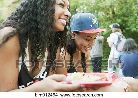 Friends hanging out and eating together View Large Photo Image Picture - Friends hanging out and eating together. Fotosearch