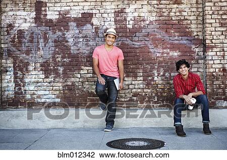 Stock Image - Friends hanging out in urban area. Fotosearch