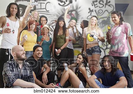 Picture - Friends hanging out together in graffitied room. Fotosearch