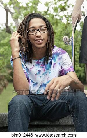 Stock Photograph - Friends hanging out with skateboards. Fotosearch