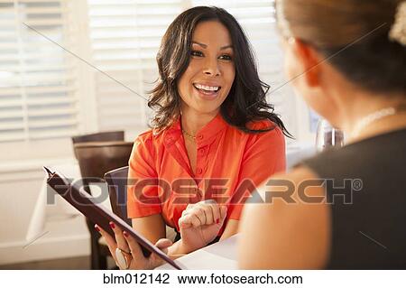Friends looking at menus in restaurant View Large Photo Image Stock Image - Friends looking at menus in restaurant. Fotosearch