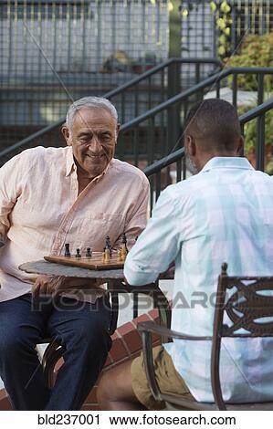 Friends playing chess in garden View Large Photo Image Stock Image - Friends playing chess in garden. Fotosearch