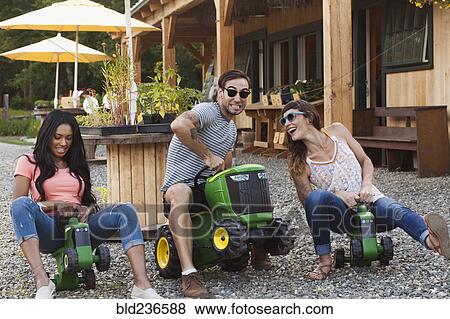Friends playing on toy tractors View Large Photo Image Stock Photo - Friends playing on toy tractors. Fotosearch