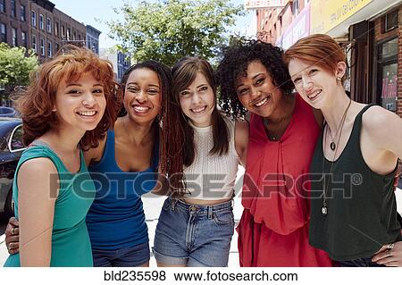 Friends smiling on city sidewalk View Large Photo Image Stock Photo - Friends smiling on city sidewalk. Fotosearch