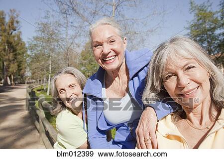 Stock Photo - Friends smiling together outdoors. Fotosearch
