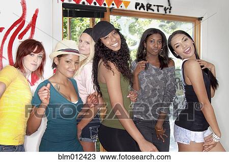 Stock Image - Friends standing together in graffitied room. Fotosearch