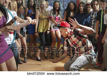 Picture - Friends watching man dancing at party. Fotosearch